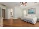 Bedroom with wood floors, a ceiling fan and a partial view of an en-suite bathroom at 3353 E Nolan Dr, Chandler, AZ 85249