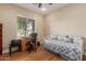 Cozy bedroom featuring hardwood floors, a daybed with patterned pillows, and a desk for a comfortable workspace at 3353 E Nolan Dr, Chandler, AZ 85249