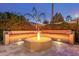 Beautifully landscaped backyard with a custom fire pit and built-in seating under the twilight sky at 3353 E Nolan Dr, Chandler, AZ 85249