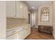 Hallway featuring custom built-in cabinets, decorative mirror, and warm tile flooring at 3353 E Nolan Dr, Chandler, AZ 85249