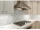 Elegant kitchen with stainless steel range hood and a stylish marble backsplash in a modern design at 3353 E Nolan Dr, Chandler, AZ 85249