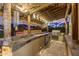 Fully equipped outdoor kitchen with a grill, mini fridge, and bar seating under a thatched roof at 3353 E Nolan Dr, Chandler, AZ 85249