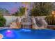 Stunning pool featuring a rock waterfall and slide, creating a luxurious backyard oasis at 3353 E Nolan Dr, Chandler, AZ 85249