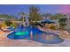 Resort-style backyard featuring a captivating pool with rock features, a waterfall, and lush tropical landscaping at 3353 E Nolan Dr, Chandler, AZ 85249
