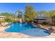 Backyard swimming pool with rock waterfall and tropical landscaping at 3353 E Nolan Dr, Chandler, AZ 85249