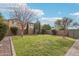 Large, grassy backyard with a brick wall, gravel landscaping and mature trees at 3471 E Azalea Dr, Gilbert, AZ 85298