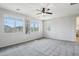 Large bedroom features plush carpeting, a ceiling fan, and two large picture windows at 3471 E Azalea Dr, Gilbert, AZ 85298