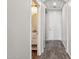 Hallway featuring wood-look floors leading to an arched entryway and a half bath at 3471 E Azalea Dr, Gilbert, AZ 85298