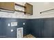 Laundry room with blue wainscoting, floral wallpaper and wood-look tile flooring at 3471 E Azalea Dr, Gilbert, AZ 85298