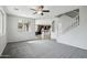 Spacious living room with gray carpet and a ceiling fan with views into the kitchen at 3471 E Azalea Dr, Gilbert, AZ 85298