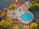 Aerial view of a sparkling pool and jacuzzi with lounge chairs surrounded by lush landscaping and shade trees at 37801 N Cave Creek Rd # 11, Cave Creek, AZ 85331