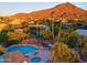 Aerial view showcases a large pool and hot tub with mountain views in the background at 37801 N Cave Creek Rd # 11, Cave Creek, AZ 85331