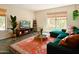 Stylish living room featuring a comfortable green sofa, large rug, and a view of the outdoors at 37801 N Cave Creek Rd # 11, Cave Creek, AZ 85331