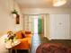 Bright living room featuring an orange sofa, decorative rug, and a view of the front door at 37801 N Cave Creek Rd # 11, Cave Creek, AZ 85331