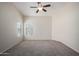 A carpeted bedroom featuring a modern ceiling fan, and a bright window for natural light at 3847 W Yellow Peak Dr, San Tan Valley, AZ 85144