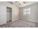 A carpeted bedroom has a ceiling fan and a sliding door closet with a shelf and hanging rod at 3847 W Yellow Peak Dr, San Tan Valley, AZ 85144