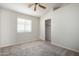 A carpeted bedroom has a ceiling fan and a sliding door closet with a shelf and hanging rod at 3847 W Yellow Peak Dr, San Tan Valley, AZ 85144
