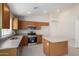 Modern kitchen featuring stainless steel appliances, wood cabinets, island, and tile flooring at 3847 W Yellow Peak Dr, San Tan Valley, AZ 85144