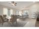 A modern living and dining area boasts sleek furniture, neutral decor, and ample natural light at 3847 W Yellow Peak Dr, San Tan Valley, AZ 85144