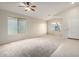 Spacious living room with tile entry, carpet, ceiling fan, and plenty of natural light from large windows at 3847 W Yellow Peak Dr, San Tan Valley, AZ 85144