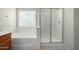 Bright main bathroom showcasing a soaking tub, glass-enclosed shower, and updated fixtures at 3847 W Yellow Peak Dr, San Tan Valley, AZ 85144