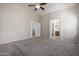 Large main bedroom featuring plush carpeting and an arched entrance to the ensuite bathroom at 3847 W Yellow Peak Dr, San Tan Valley, AZ 85144