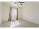 Bedroom featuring neutral carpet, window with curtains, and a ceiling fan at 3935 E Rough Rider Rd # 1264, Phoenix, AZ 85050