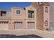 View of a two-story townhome with two-car garage and a balcony, and desert landscaping at 3935 E Rough Rider Rd # 1264, Phoenix, AZ 85050