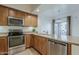 Kitchen featuring stainless steel appliances, wooden cabinetry, and granite countertops at 3935 E Rough Rider Rd # 1264, Phoenix, AZ 85050