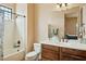 Bathroom featuring a white tub, wood cabinets, and a shower with a glass door at 40627 N 6Th Ave, Phoenix, AZ 85086