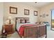 Primary bedroom with wood trim and furniture, view of desert landscape, and neutral carpet at 40627 N 6Th Ave, Phoenix, AZ 85086