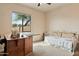 Neutral bedroom featuring a comfortable daybed, large window with natural light, and a charming sewing machine table at 40627 N 6Th Ave, Phoenix, AZ 85086