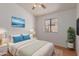 Tranquil bedroom featuring a large bed, ocean art, and soft, natural lighting at 4450 E Amberwood Dr, Phoenix, AZ 85048