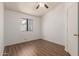 Bedroom with neutral walls, wood floors, and a bright window at 4450 E Amberwood Dr, Phoenix, AZ 85048
