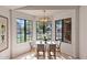 Inviting dining area with natural light, modern chandelier, and table set for four with views to the outdoors at 4450 E Amberwood Dr, Phoenix, AZ 85048