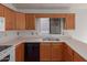 Well-lit kitchen featuring wood cabinets, a stainless steel sink, and modern appliances at 4450 E Amberwood Dr, Phoenix, AZ 85048