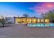 Amazing backyard with a modern home, pool, patio and an outdoor cooking area at dusk at 5033 E Turquoise Ave, Paradise Valley, AZ 85253