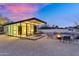 Backyard with outdoor dining, fire pit, and a glass house with a bedroom in the distance at 5033 E Turquoise Ave, Paradise Valley, AZ 85253