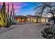 Stunning modern home with desert landscaping, cacti and a gravel driveway at twilight at 5033 E Turquoise Ave, Paradise Valley, AZ 85253