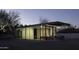 Contemporary glass home at dusk with warm interior lighting and minimal design at 5033 E Turquoise Ave, Paradise Valley, AZ 85253