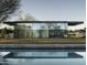 Modern glass home with a pool reflecting the architecture at 5033 E Turquoise Ave, Paradise Valley, AZ 85253