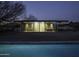 Sleek glass home exterior at twilight with inviting interior lighting at 5033 E Turquoise Ave, Paradise Valley, AZ 85253