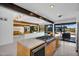 Bright, open kitchen with an island cooktop and views of the outdoor pool and living areas at 5033 E Turquoise Ave, Paradise Valley, AZ 85253
