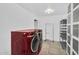 Modern laundry room featuring a red washer and dryer set with shelving and tiled floors at 5033 E Turquoise Ave, Paradise Valley, AZ 85253