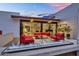 Elegant outdoor patio featuring red seating, a fire feature, and views into the home at 5033 E Turquoise Ave, Paradise Valley, AZ 85253