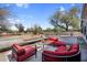 Inviting outdoor patio featuring red furniture, a coffee table with citrus, and desert landscaping at 5033 E Turquoise Ave, Paradise Valley, AZ 85253