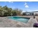 Inviting backyard featuring a sparkling pool with stone tile surround and a modern glass home design at 5033 E Turquoise Ave, Paradise Valley, AZ 85253