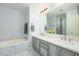 Bathroom featuring double vanity and marble tiling around the bathtub at 5450 E Deer Valley Dr # 2023, Phoenix, AZ 85054