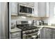Modern kitchen appliances, including a stainless steel gas range, microwave, and granite countertops at 5450 E Deer Valley Dr # 2023, Phoenix, AZ 85054