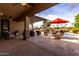 Back patio featuring a dining area, seating, and desert landscaping with a pool in the background at 560 W Powell Way, Chandler, AZ 85248